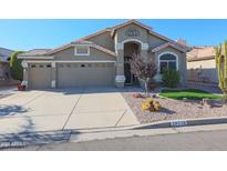 Single-story house with a two-car garage and landscaped front yard at 19778 N Coyote Lakes Pkwy, Surprise, AZ 85378