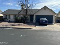 Single-story home with gray roof and attached garage at 2429 E Calypso Ave, Mesa, AZ 85204