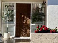 Inviting entryway with a unique, ornate wooden door and lush landscaping at 6318 N 14Th St, Phoenix, AZ 85014