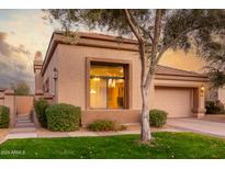 Tan stucco house with a large window, attached garage, and landscaped yard at 8100 E Camelback Rd # 175, Scottsdale, AZ 85251