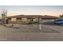 Brick ranch house with a two-car garage and well-maintained landscaping at 9403 W Fern Dr, Sun City, AZ 85351