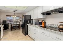 Modern kitchen with granite countertops and stainless steel appliances at 9403 W Fern Dr, Sun City, AZ 85351