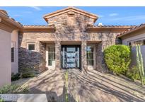 Inviting front exterior with stone accents and a modern entryway at 9740 E Lofty Point Rd, Scottsdale, AZ 85262