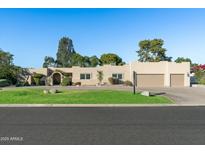 Single-story home with a three-car garage and landscaped front yard at 7032 E Dreyfus Ave, Scottsdale, AZ 85254