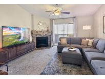 Bright living room featuring a fireplace and sliding glass door to balcony at 1880 E Morten Ave # 206, Phoenix, AZ 85020