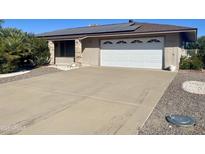 Ranch-style home with solar panels, attached garage, and spacious driveway at 19621 N Palo Verde Dr, Sun City, AZ 85373