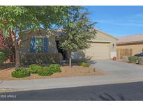 House exterior with tan walls, blue shutters, and a two-car garage at 27194 N Skipping Rock Rd, Peoria, AZ 85383