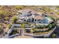 Expansive desert home featuring a tile roof, pool, landscaping, and outdoor seating areas at 5655 N Camelback Canyon Dr, Phoenix, AZ 85018