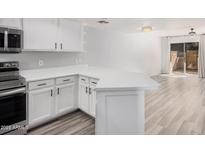 Modern kitchen with white cabinets, stainless steel appliances, and an island at 6454 E University Dr # 24, Mesa, AZ 85205