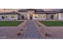 Inviting single-story home featuring a stone facade, manicured landscaping, and a walkway leading to the front door at 6614 E North Ln, Paradise Valley, AZ 85253