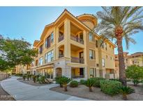 Luxury 3-story building with Spanish-style architecture, palm trees, and manicured landscaping at 7275 N Scottsdale Rd # 1001, Paradise Valley, AZ 85253