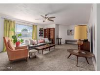 Spacious living room with mid-century furniture, wood shelving and large windows at 936 E 8Th Pl, Mesa, AZ 85203