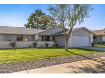 Ranch style home with landscaped lawn and attached garage at 12719 W Shadow Hills Dr, Sun City West, AZ 85375