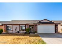 Brick ranch house with attached garage and landscaped yard at 2047 E Devon Rd, Gilbert, AZ 85296