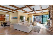 Spacious living room with stone fireplace, high ceilings, and access to backyard at 7575 E Camino Salida Del Sol --, Scottsdale, AZ 85266