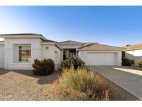 Single-story home with white exterior, two-car garage, and desert landscaping at 9323 E Arrowvale Dr, Sun Lakes, AZ 85248