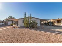 Single-wide manufactured home with covered carport and desert landscaping at 1126 S 97Th Way, Mesa, AZ 85208