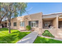 Well-maintained stucco home with grassy yard and walkway at 14300 W Bell Rd # 5, Surprise, AZ 85374