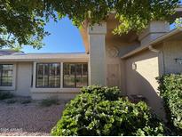 Tan stucco house with security door, large windows, and landscaping at 20205 N Broken Arrow Dr, Sun City West, AZ 85375