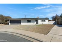 House exterior with gray garage door and landscaping at 2046 E Alder Cir, Mesa, AZ 85204