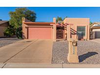 Tan stucco house with a pink garage door and a gravel driveway at 26430 S Pinewood Dr, Sun Lakes, AZ 85248