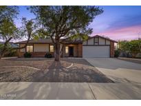 Brick ranch house with a two-car garage and mature landscaping at 2647 E Evergreen St, Mesa, AZ 85213