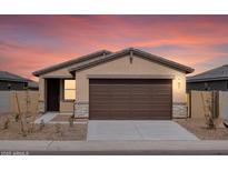 Charming single-story home with a two-car garage and desert landscaping at sunset at 3208 E Hayden Rose Ave, San Tan Valley, AZ 85143