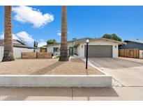 Modern single story home with landscaped front yard and attached garage at 3929 E Mercer Ln, Phoenix, AZ 85028