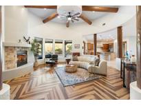 Open living room with a curved sofa, fireplace, and wood beams at 6708 E Calle De Las Estrellas Rd, Cave Creek, AZ 85331