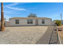 Charming single story home featuring a paved drive, neutral paint, desert landscaping and mature palm tree at 8155 E Baltimore St, Mesa, AZ 85207