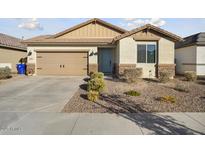 Attractive single-story home with a well-maintained front yard and an attached two-car garage at 16790 W Molly Ln, Surprise, AZ 85387