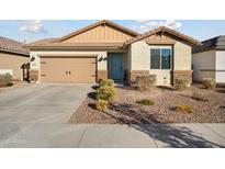 Charming single-story home featuring a two-car garage, desert landscaping, and a welcoming blue front door at 16790 W Molly Ln, Surprise, AZ 85387