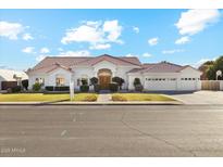 Charming single-story home with lush lawn, mature landscaping, and a three-car garage at 1743 E Menlo St, Mesa, AZ 85203