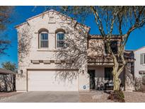 Two-story house with a white garage door and landscaping at 17774 W Watson Ln, Surprise, AZ 85388