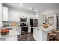 Bright kitchen features stainless steel appliances, white cabinets, and a functional center island at 22125 N 29Th Ave # 127, Phoenix, AZ 85027