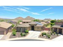 Single-story home with solar panels, a landscaped yard, and mountain views at 28957 N 70Th Dr, Peoria, AZ 85383