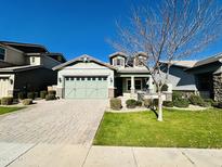 Single-story home with green exterior, two-car garage, and landscaped yard at 3448 E Spring Wheat Ln, Gilbert, AZ 85296