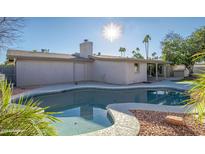 Inviting kidney-shaped pool with a spa, surrounded by rock landscaping at 6630 E Dreyfus Ave, Scottsdale, AZ 85254