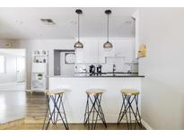 Modern kitchen features white cabinets, quartz countertops, and a breakfast bar with sleek stools at 7245 E Cambridge Ave, Scottsdale, AZ 85257