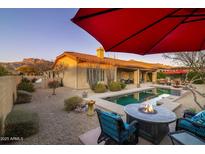 Inviting backyard oasis with a sparkling pool, fire pit, and seating at 8531 E Twisted Leaf Dr, Gold Canyon, AZ 85118