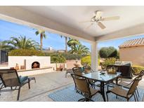Covered patio featuring an outdoor fireplace, seating, and desert landscaping at 12808 W Nogales Dr, Sun City West, AZ 85375
