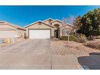Tan house with white garage door and landscaping at 3854 W Yellow Peak Dr, San Tan Valley, AZ 85144
