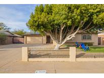 Single-story home with a large tree, driveway, and landscaped yard at 8644 E Roanoke Ave, Scottsdale, AZ 85257