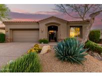 Desert landscaping surrounds this single-story home with a neutral stucco exterior and arched entryway at 11509 E Beck Ln, Scottsdale, AZ 85255