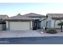 Single-story home with tile roof, two-car garage, and well-manicured landscaping at 14371 W Morning Star Trl, Surprise, AZ 85374