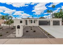 Stunning modern home featuring a well-manicured front yard, clean lines, and a spacious driveway leading to a two-car garage at 6712 E Pershing Ave, Scottsdale, AZ 85254