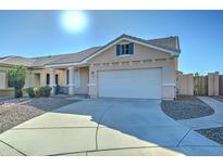 Beige house with a two-car garage and a gravel driveway at 7037 W Pontiac Dr, Glendale, AZ 85308