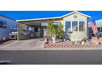Inviting manufactured home exterior, featuring a covered carport and well-maintained landscaping at 7750 E Broadway Rd # 770, Mesa, AZ 85208