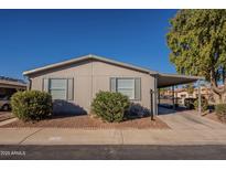 Tan single-wide manufactured home with carport and landscaping at 11275 N 99Th Ave # 188, Peoria, AZ 85345