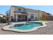 Home with a kidney-shaped pool, covered patio, and grassy area at 17338 W Woodrow Ln, Surprise, AZ 85388